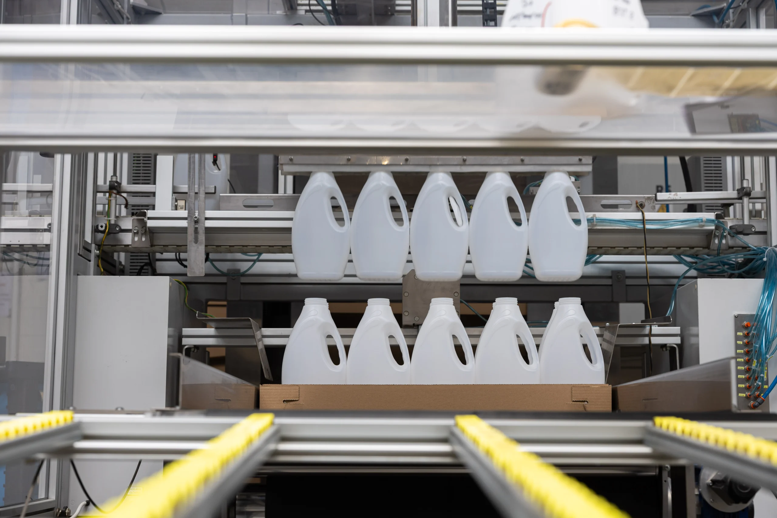 White plastic canisters with handles on a production line
